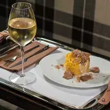 Un bicchiere di vino bianco e un piatto di pasta condita con abbondante tartufo. Un perfetto abbinamento vino tartufo per un'esperienza gourmet.
