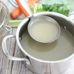 Un fumetto di pesce, filtrato in una ciotola, con verdure e brodo pronto in pentola.