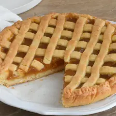 Una deliziosa crostata di marmellata con una griglia dorata di pasta frolla, pronta per essere gustata.