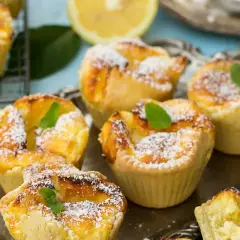 Deliziosi tortini di budino di riso, spolverati di zucchero a velo e guarniti con menta fresca, su un vassoio d'argento.