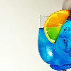 Un rinfrescante spritz blu con una fetta d'arancia, pieno di ghiaccio.
