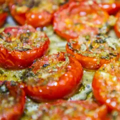 Pomodorini confit cotti al forno, succosi e dorati, pronti per essere gustati.