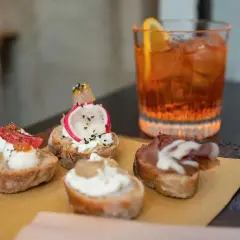 Deliziosi stuzzichini e un drink colorato per un perfetto aperitivo all'italiana.