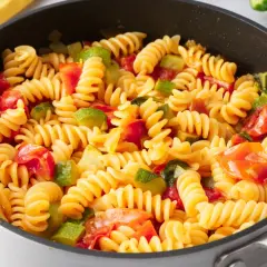 Fusilli con zucchine e pomodorini freschi, un piatto colorato e saporito, pronto per essere gustato.