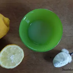 Limoni, succo di limone in ciotola verde e un cucchiaino di bicarbonato al posto del lievito per dolci.