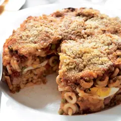 Un invitante anelletti al forno, stratificato con uova sode, piselli e ragù, con una croccante panatura dorata.