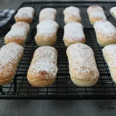 Savoiardi appena sfornati, spolverati di zucchero a velo, pronti per la tua ricetta.