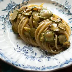 Spaghetti alla Nerano, un piatto cremoso con zucchine fresche su un piatto decorato.