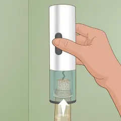 Mano che usa un cavatappi elettrico per rimuovere un tappo da una bottiglia di vino.