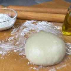 Impasto per pasta brisè con olio e vino bianco, farina e mattarello pronti per creare delizie.