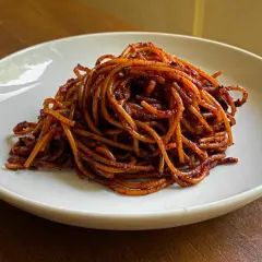 Un piatto di spaghetti all'assassina, conditi con un sugo rosso piccante e saporito, pronti per essere gustati.