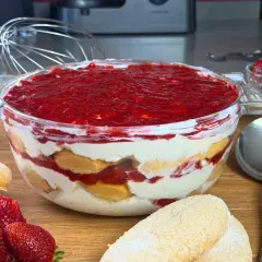 Un goloso tiramisù fragola in una ciotola di vetro, con savoiardi, crema e tanta fragola fresca.