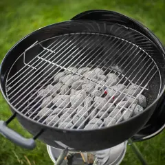 Carbone pronto per accendersi, quanta carbonella per una grigliata perfetta! La griglia è posizionata sopra, in attesa di cibo succulento.