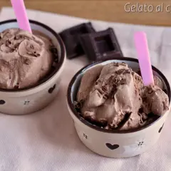 Due coppette di cremoso gelato al cioccolato, guarnite con scaglie di cioccolato e cucchiaini rosa.
