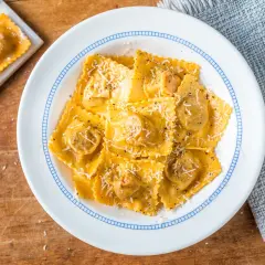 Tortelli di zucca ricetta originale, un piatto invitante con pasta fresca ripiena, condita con parmigiano e pepe nero.