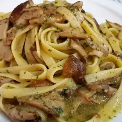 Un piatto invitante di tagliatelle ai funghi porcini, condite con erbe aromatiche e un sugo saporito.