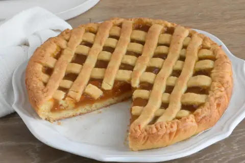 Una deliziosa crostata di marmellata con una griglia dorata di pasta frolla, pronta per essere gustata.
