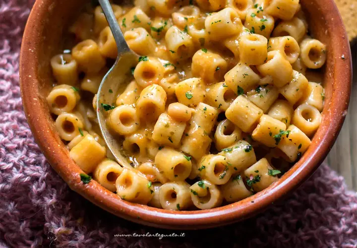 Un piatto fumante di pasta e fagioli, con ditalini e fagioli cannellini in un sugo cremoso, guarnito con prezzemolo tritato.