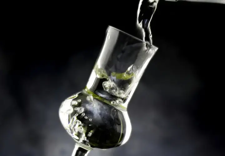 Versando grappa in un bicchiere speciale, creando bollicine e un'atmosfera invitante.