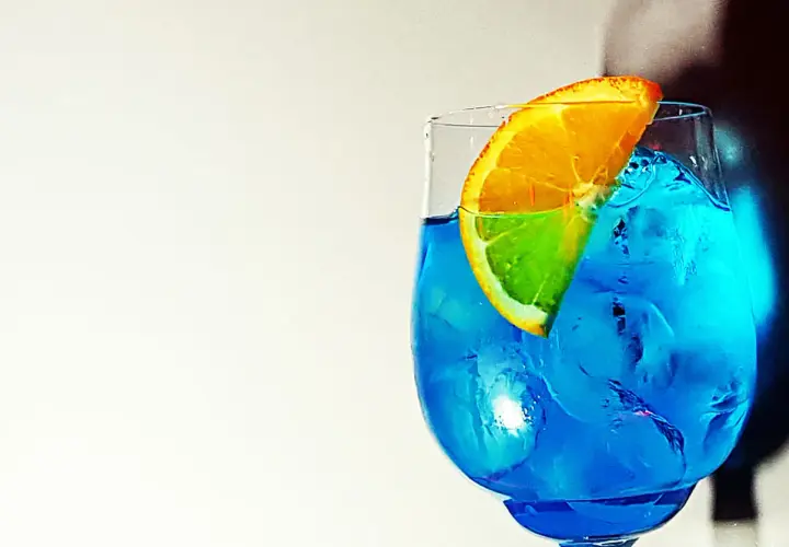 Un rinfrescante spritz blu con una fetta d'arancia, pieno di ghiaccio.