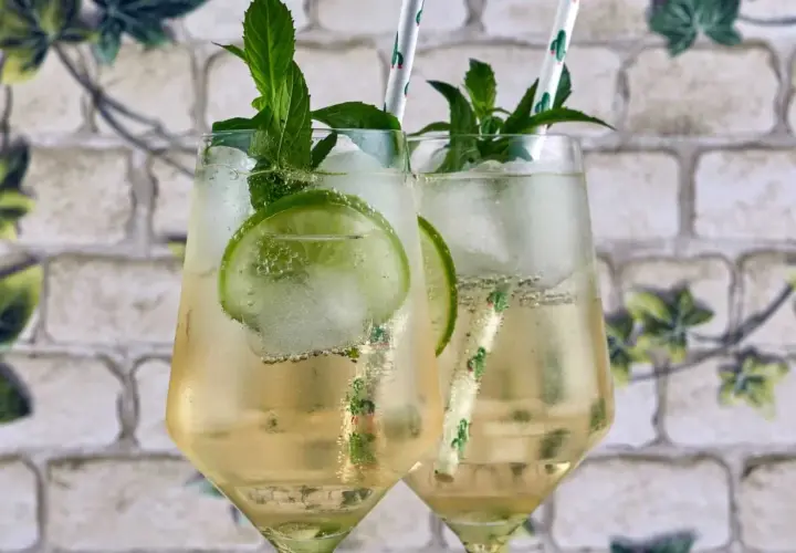 Due Hugo Spritz, con menta fresca, lime e ghiaccio. Ingredienti perfetti per un'estate rinfrescante.