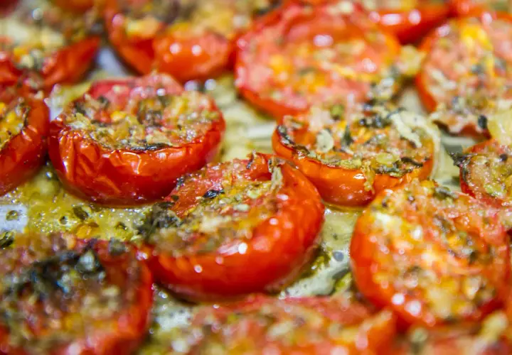 Pomodorini confit cotti al forno, succosi e dorati, pronti per essere gustati.
