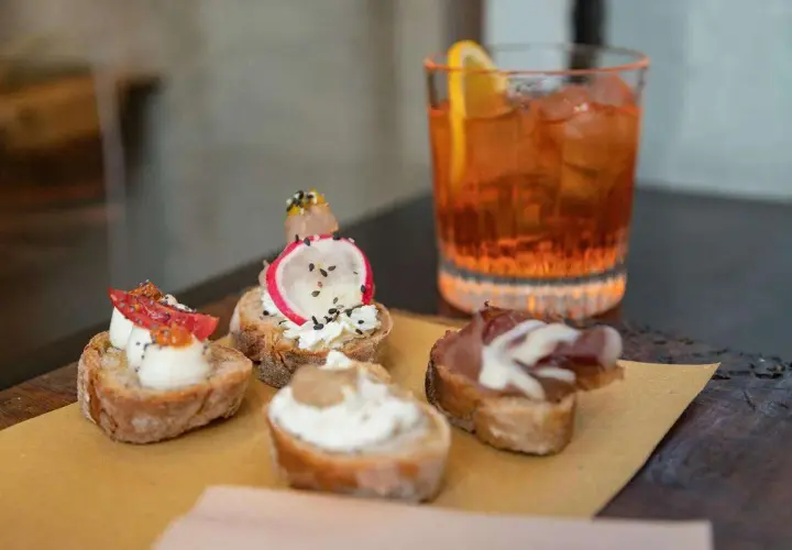 Deliziosi stuzzichini e un drink colorato per un perfetto aperitivo all'italiana.
