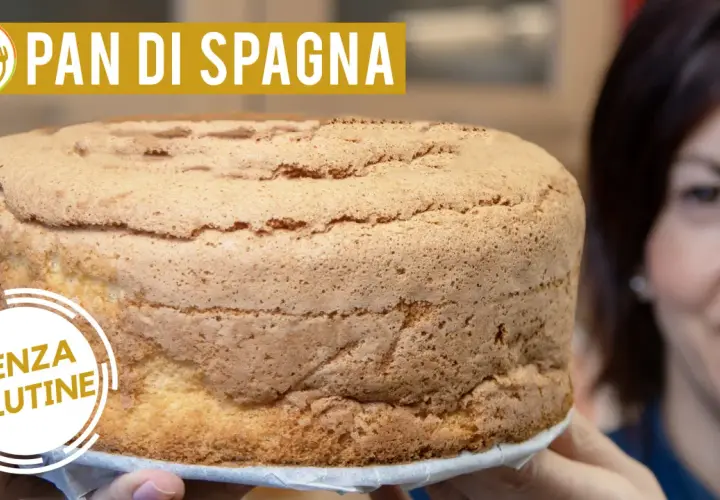 Un soffice pan di spagna senza glutine, dorato e invitante, tenuto da mani sorridenti.