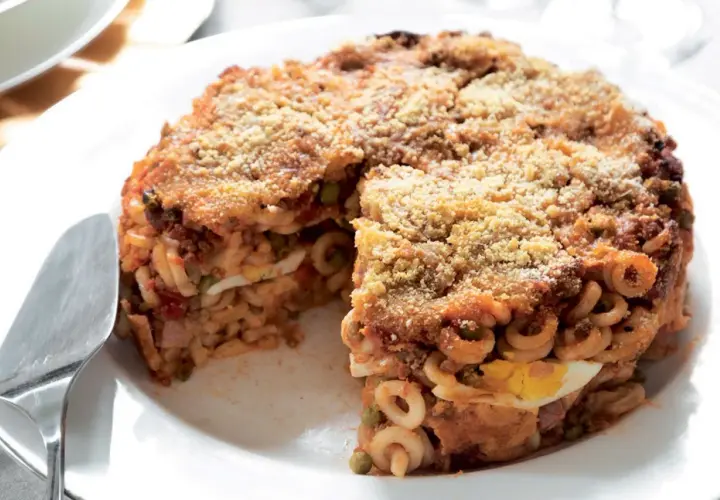 Un invitante anelletti al forno, stratificato con uova sode, piselli e ragù, con una croccante panatura dorata.