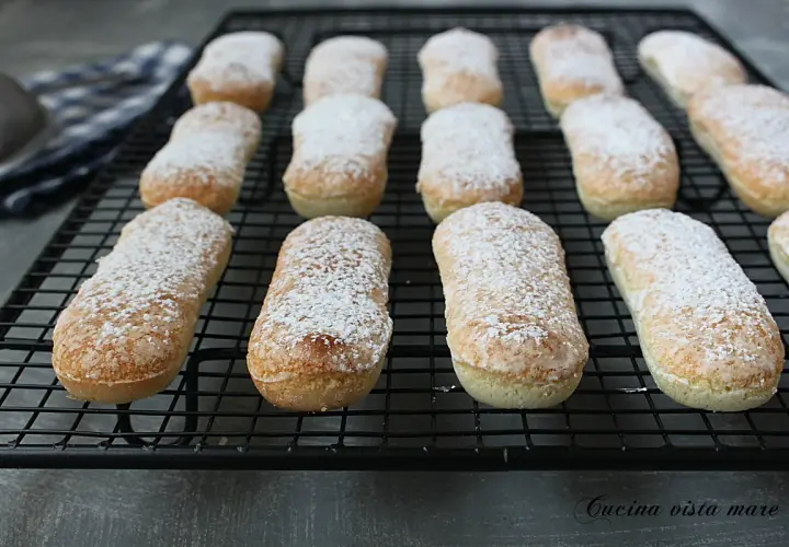 Savoiardi appena sfornati, spolverati di zucchero a velo, pronti per la tua ricetta.