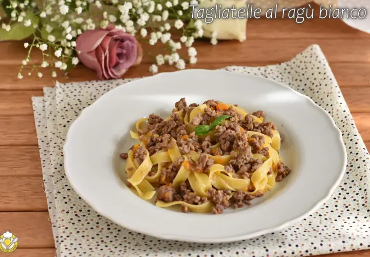 Tagliatelle al ragù bianco, un piatto gustoso con carne macinata e verdure, guarnito con basilico.