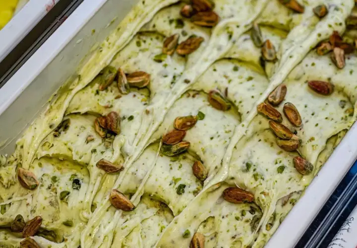 Gelato cremoso al pesto di pistacchi, guarnito con pistacchi interi tostati.
