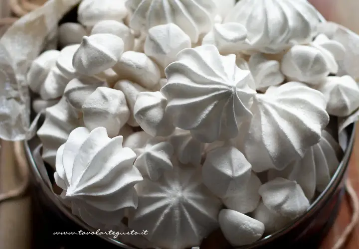 Un cesto pieno di meringhe soffici, perfette per la tua ricetta. Dolci e leggere, invitano a essere gustate.