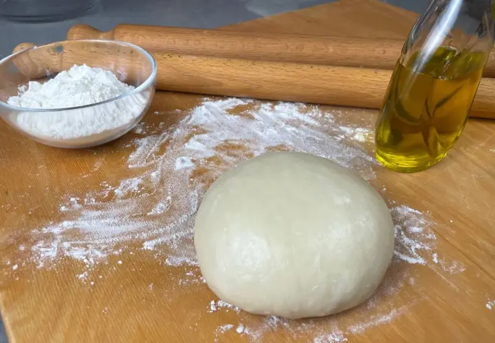 Impasto per pasta brisè con olio e vino bianco, farina e mattarello pronti per creare delizie.
