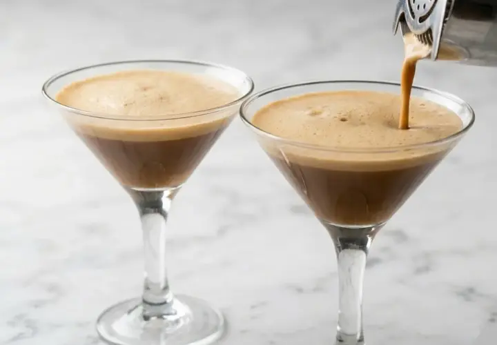 Due bicchieri di caffè shakerato con schiuma cremosa, uno viene riempito da uno shaker.