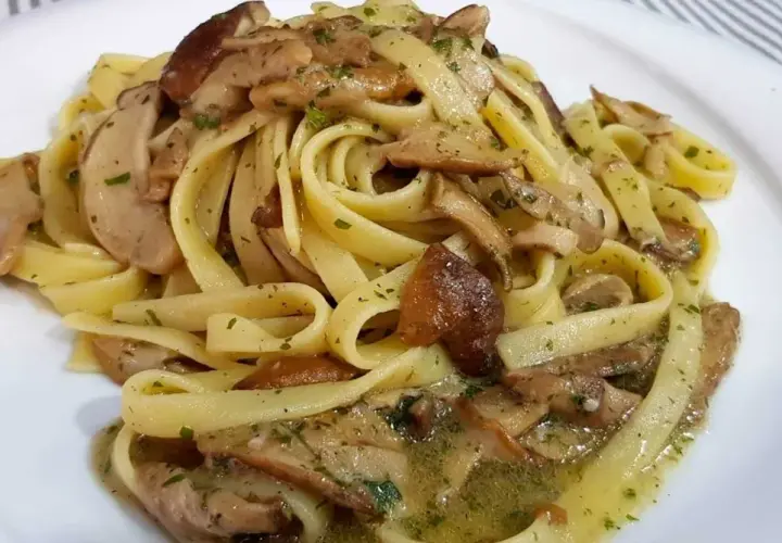 Un piatto invitante di tagliatelle ai funghi porcini, condite con erbe aromatiche e un sugo saporito.