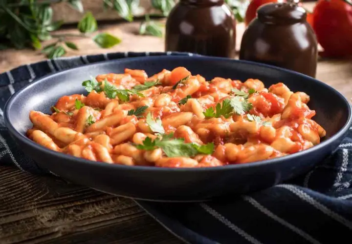 Piatto di pasta fagioli e cozze, un classico della cucina italiana, guarnito con prezzemolo fresco.