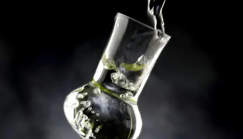 Versando grappa in un bicchiere speciale, creando bollicine e un'atmosfera invitante.