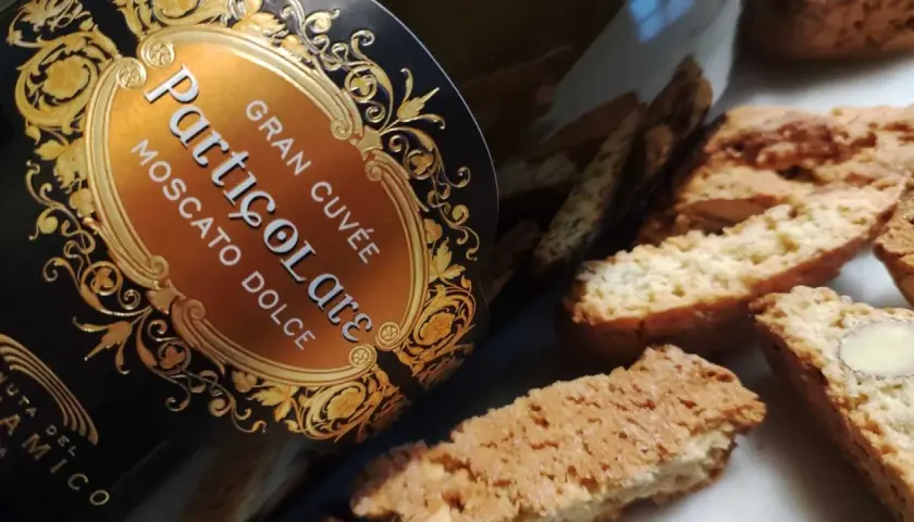Un bicchiere di prosecco per dolce, accompagnato da cantucci alle mandorle.