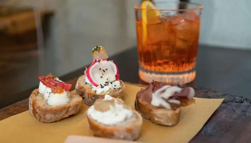 Deliziosi stuzzichini e un drink colorato per un perfetto aperitivo all'italiana.