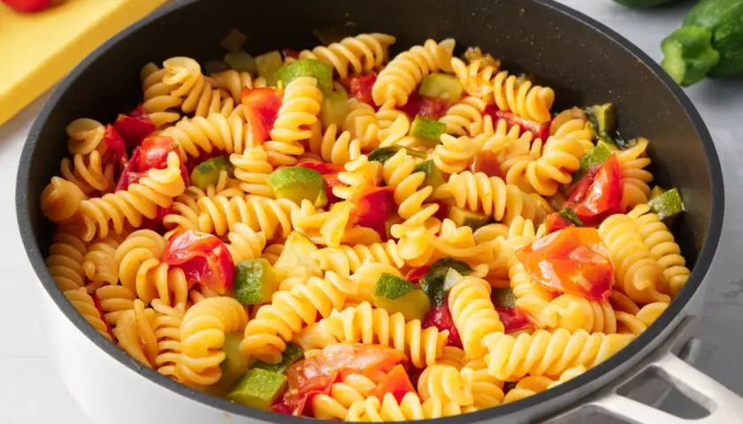 Fusilli con zucchine e pomodorini freschi, un piatto colorato e saporito, pronto per essere gustato.