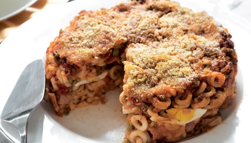Un invitante anelletti al forno, stratificato con uova sode, piselli e ragù, con una croccante panatura dorata.