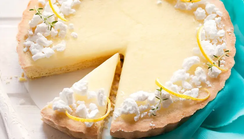 Deliziosa crostata al limone con meringhe e scorzette, una fetta è già stata servita.