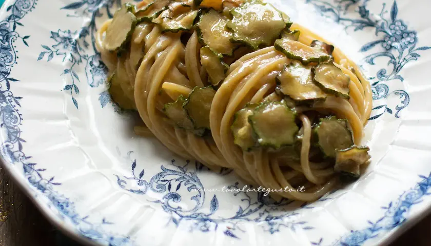 Spaghetti alla Nerano, un piatto cremoso con zucchine fresche su un piatto decorato.