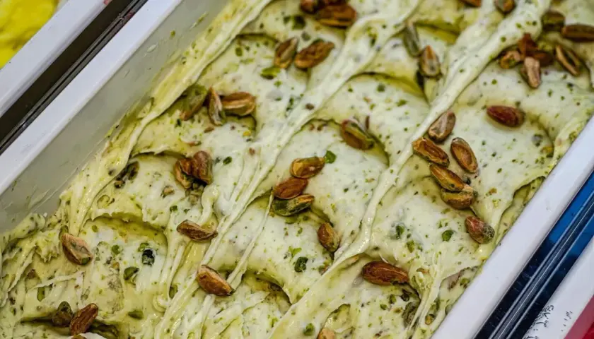 Gelato cremoso al pesto di pistacchi, guarnito con pistacchi interi tostati.