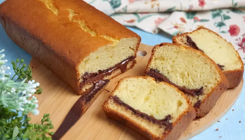 Plumcake soffice con cuore di cioccolato, perfetto per la tua ricetta. Fette golose su tagliere di legno.