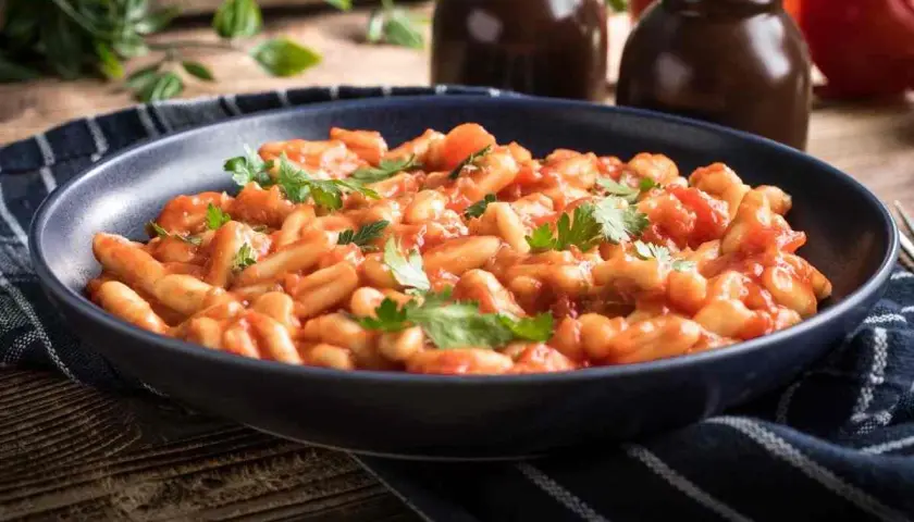 Piatto di pasta fagioli e cozze, un classico della cucina italiana, guarnito con prezzemolo fresco.