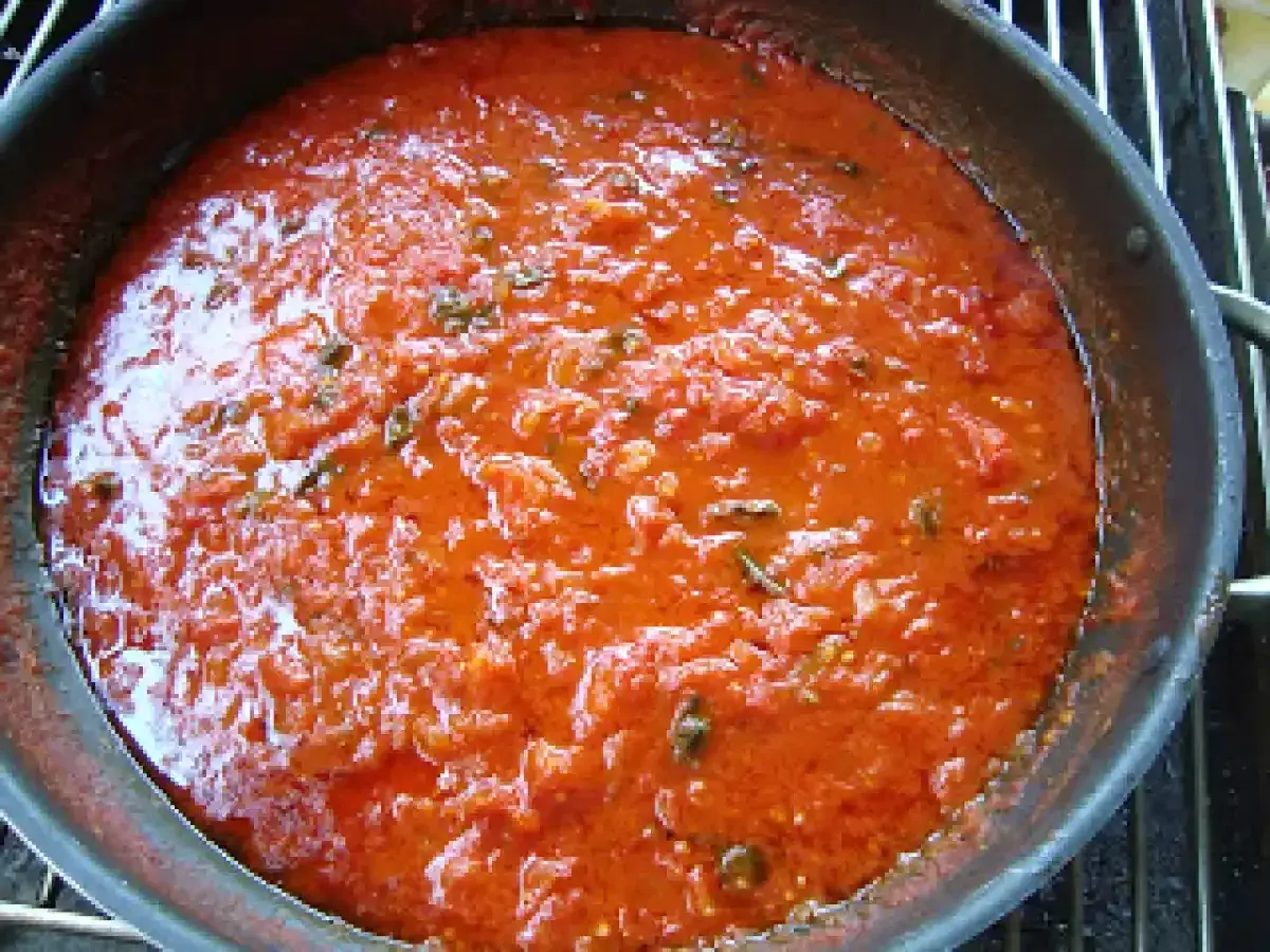 Sugo di pomodoro fresco in padella, profumato con erbe aromatiche, pronto per condire la pasta.