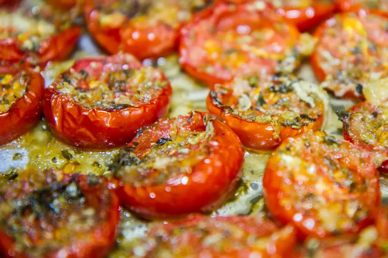 Pomodorini confit cotti al forno, succosi e dorati, pronti per essere gustati.
