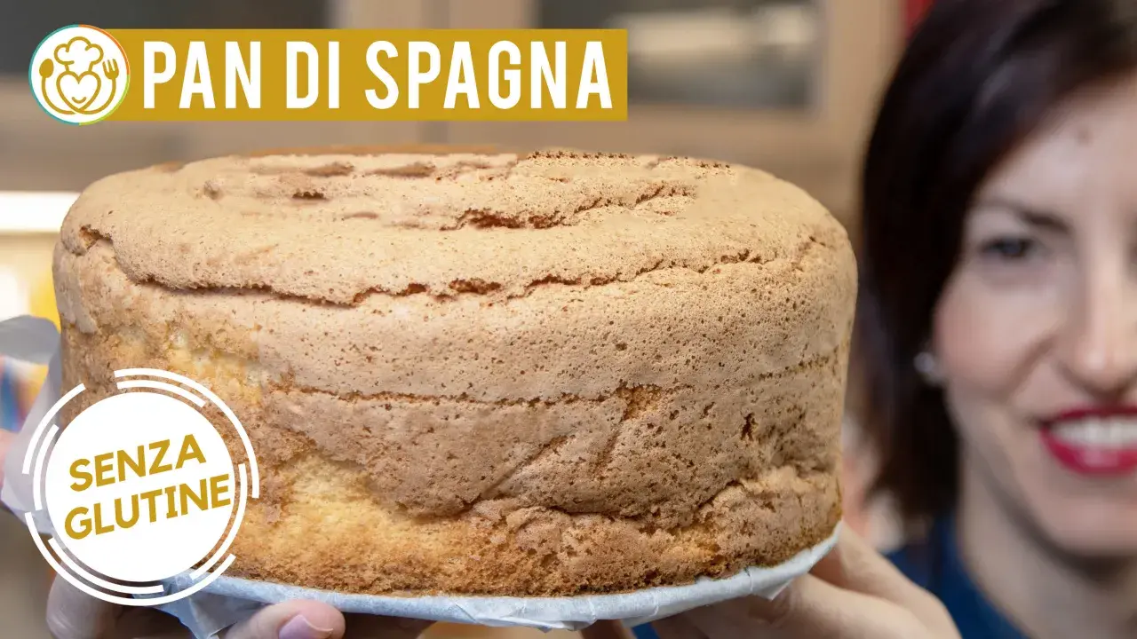 Un soffice pan di spagna senza glutine, dorato e invitante, tenuto da mani sorridenti.